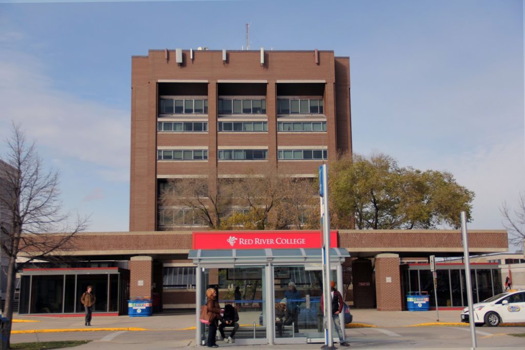 Large brick building with a bush shelter and sign Red River College. 